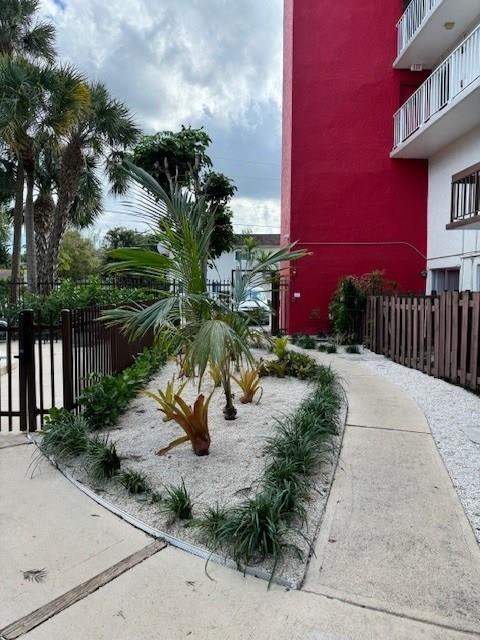 a courtyard with palm trees in front of a red building