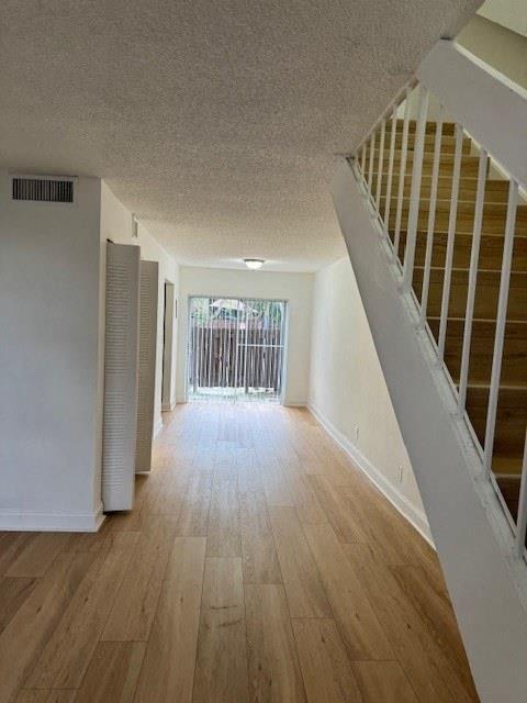 a empty room with a staircase and wood floors