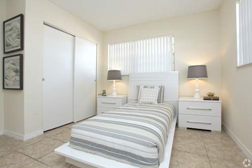 A bedroom with a bed, nightstands, and a painting on the wall.