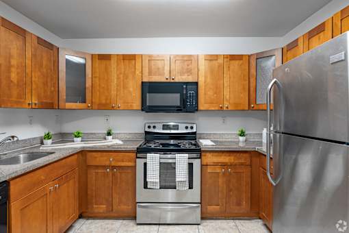 A kitchen with wooden cabinets and stainless steel appliances.