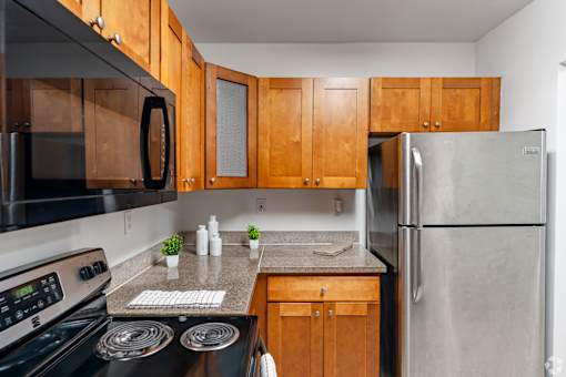 A kitchen with wooden cabinets and a black stove top.