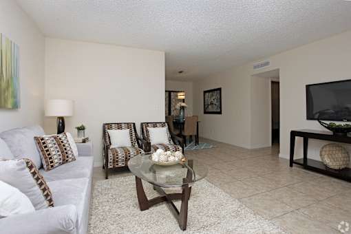 A living room with a couch, chairs, and a coffee table.