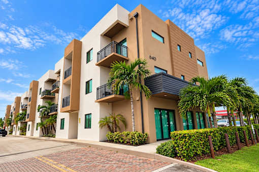 A modern building with balconies and green doors.