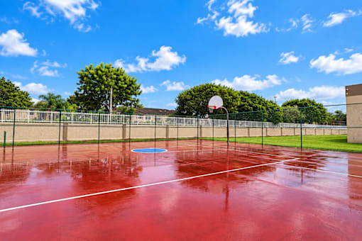 A red tennis court with a blue circle in the middle.
