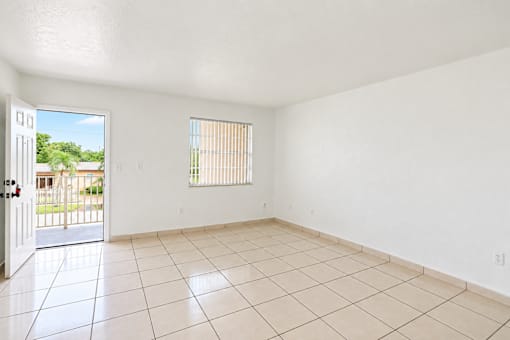 A room with white walls and a tiled floor with a door and window.