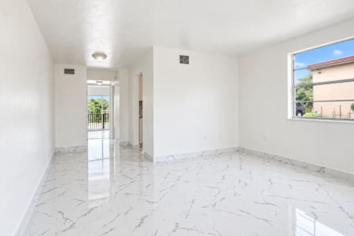 A white room with marble flooring and a window.