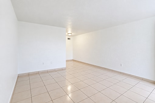 A white room with a tiled floor and a light on the ceiling.