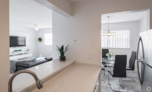 A kitchen with a sink and a dining table.