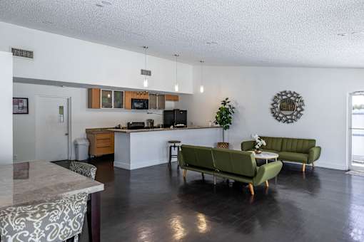 A kitchen with a green couch and a table.