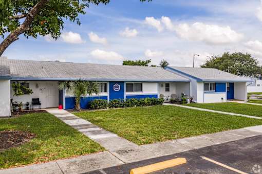 A blue and white building with a red stop sign on the door.