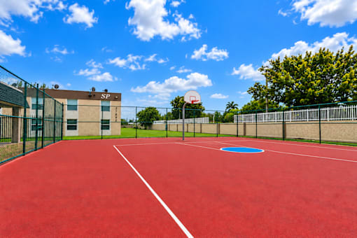 A red basketball court with a blue circle in the middle.