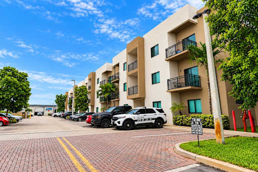 A white building with a black SUV in front of it.