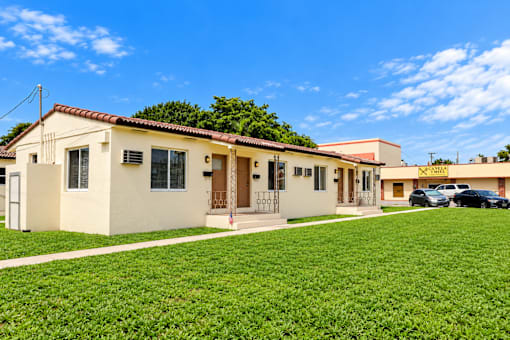 A house with a green lawn in front of it.