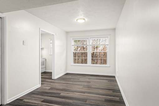 A room with a window and a wooden floor.