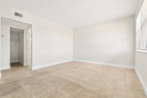 A room with a tiled floor and a doorway leading to another room.