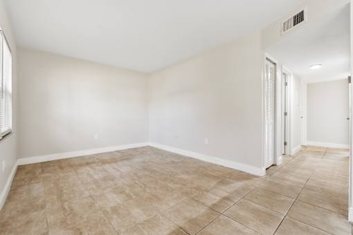 A room with beige tiled flooring and white walls.