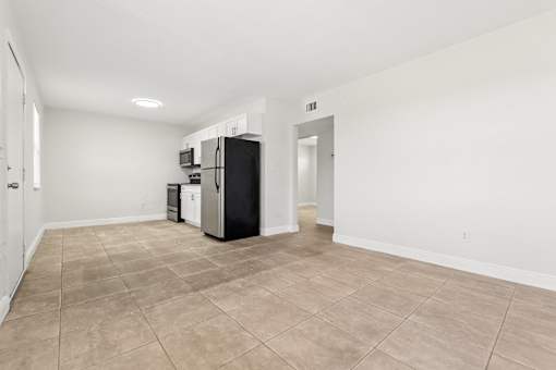 A kitchen area with a refrigerator, microwave, and dishwasher.