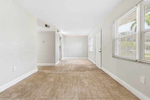 A long, empty hallway with tiled flooring and white walls.