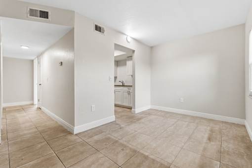 A large empty room with beige walls and flooring.