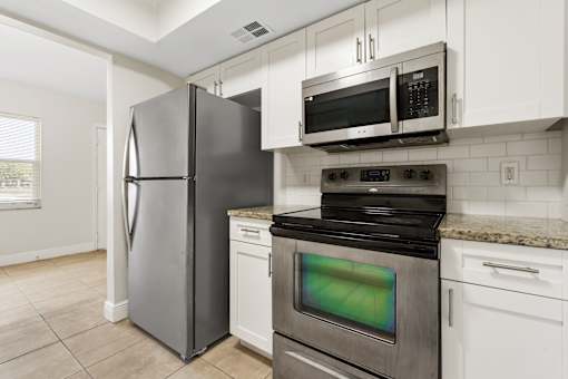 A kitchen with a stainless steel refrigerator and oven.