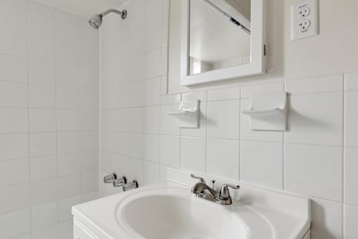 A white sink in a bathroom with a mirror above it.