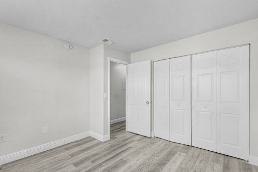 A room with a white door and a white wall.