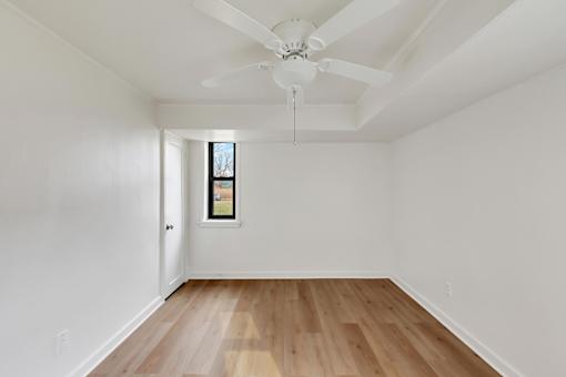 A room with a ceiling fan and a window.