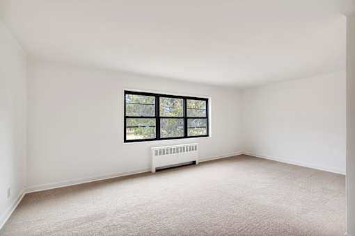 A room with a window and a radiator on the wall.