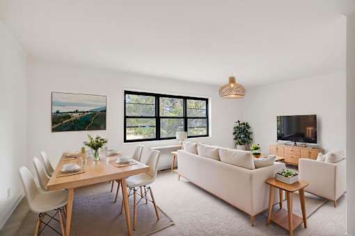A modern living room with a dining table set for two.