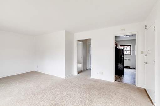 A large empty room with a doorway leading to another room.