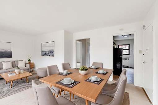 A dining room with a wooden table set for six.