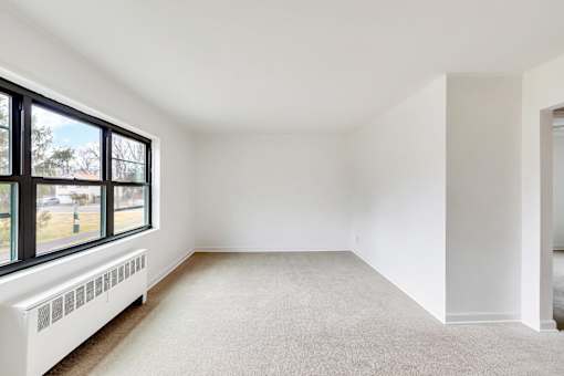 A room with a window and a radiator on the wall.