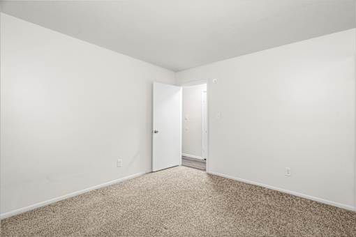 A room with a carpeted floor and white walls.