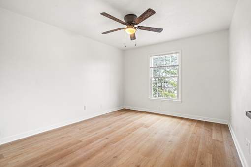 A room with a ceiling fan and a window.