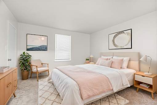 A bedroom with a large bed and a painting on the wall.