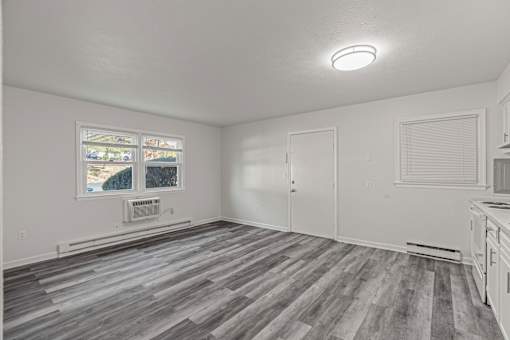 A room with a window and a wooden floor.