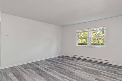 A room with a window and a grey floor.
