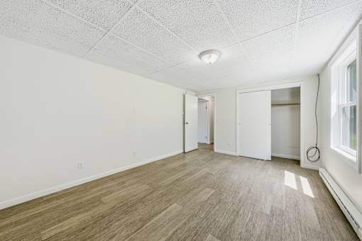 A room with wooden flooring and white walls.
