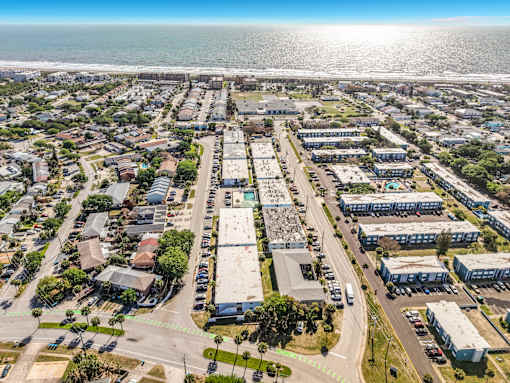 A bird's eye view of a coastal town with buildings, roads, and the ocean in the background.
