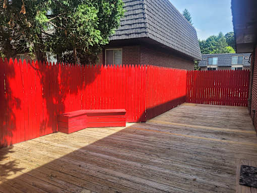 A red fence surrounds a wooden deck.