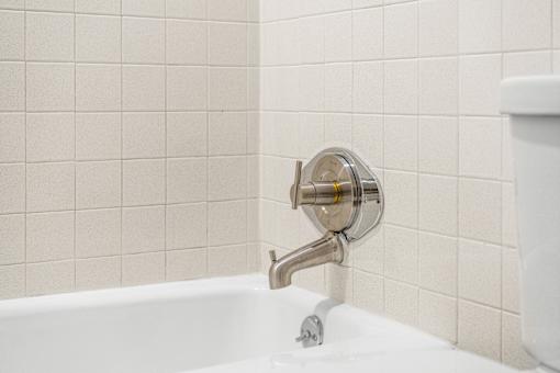 A white bathtub with a chrome faucet and shower head.