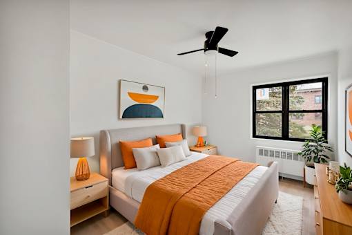 A bedroom with a bed, nightstands, and a ceiling fan.