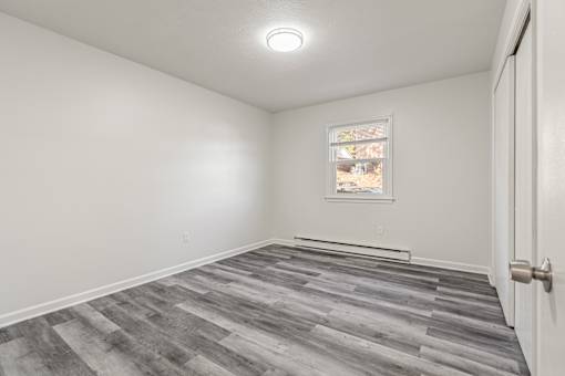 A room with a grey floor and a white door.