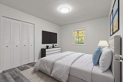A bedroom with a bed, dresser, and wardrobe.