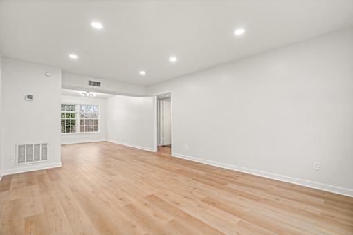 A room with wooden flooring and white walls.
