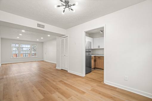 A spacious room with wooden floors and a ceiling fan.