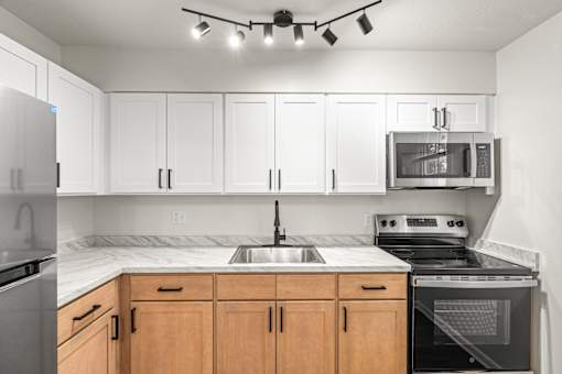 A kitchen with white cabinets and a black stove top oven.