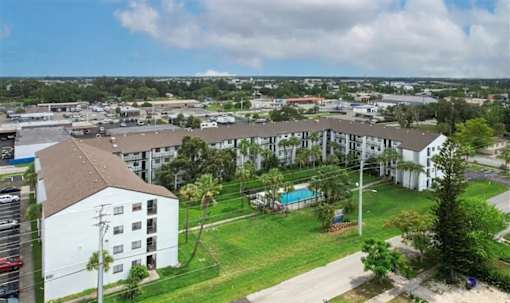 A view of a residential area with apartment buildings and a swimming pool.