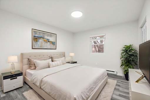 A bedroom with a large bed and a painting on the wall.