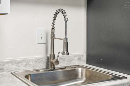 A modern kitchen sink with a chrome faucet.